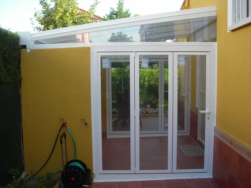 Cerramiento de patio lateral con puertas de aluminio blanco