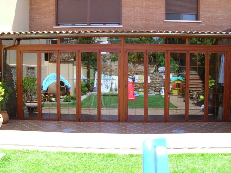 Porche de chalet con cerramiento plegable imitación madera cerrado