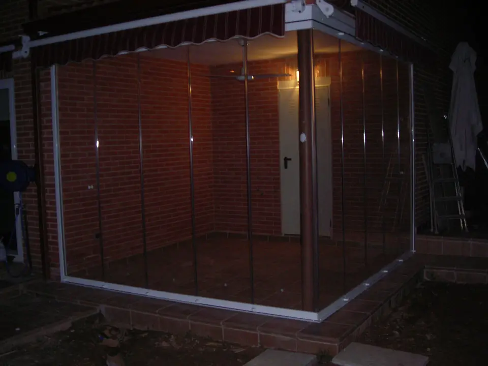 Terraza cerrada con cortinas de cristal de noche