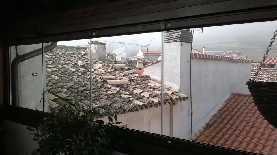Cortinas de cristal en terraza con vistas a los tejados