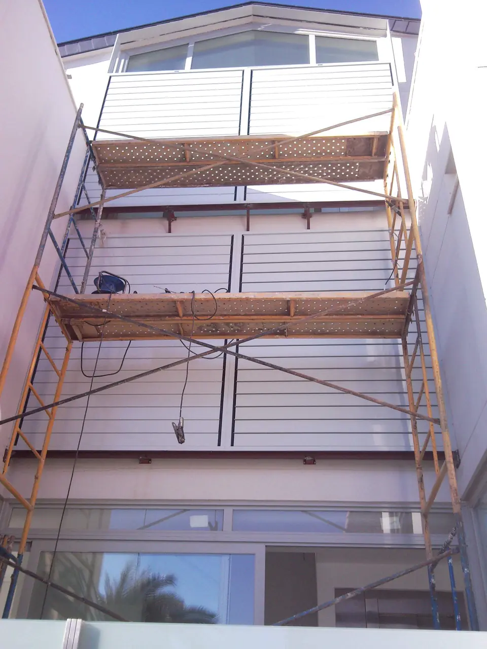 Fachada con lamas de aluminio y andamio