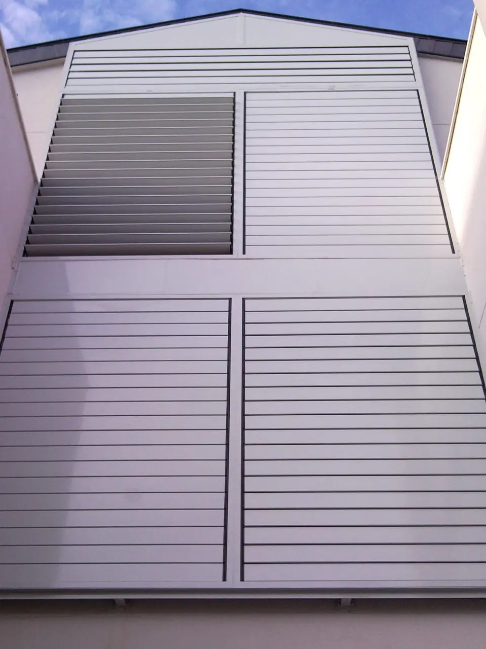 Fachada terminada con lamas y celosía de aluminio