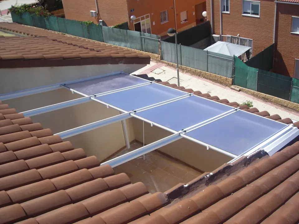 Techo de aluminio y policarbonato sobre patio entre tejados